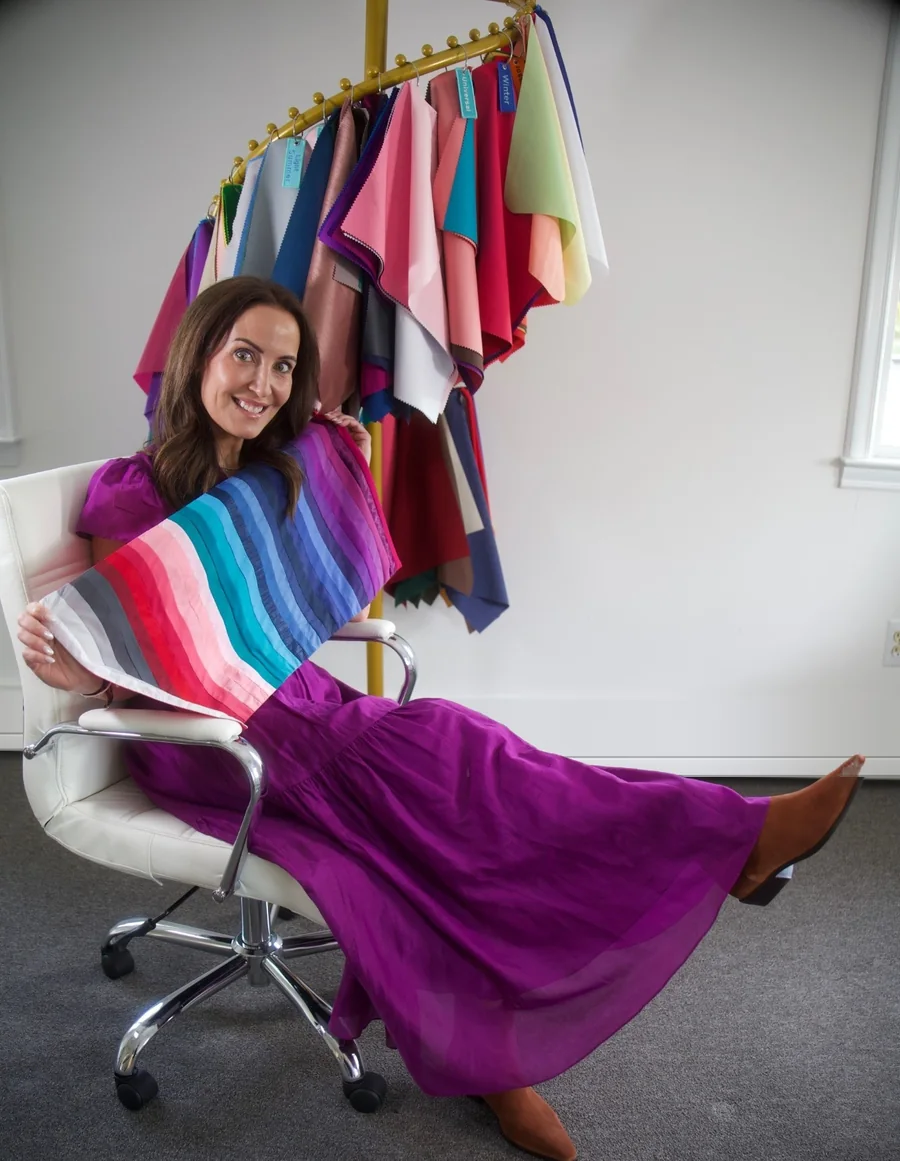Kate holding a fan of professional color drapes in her studio